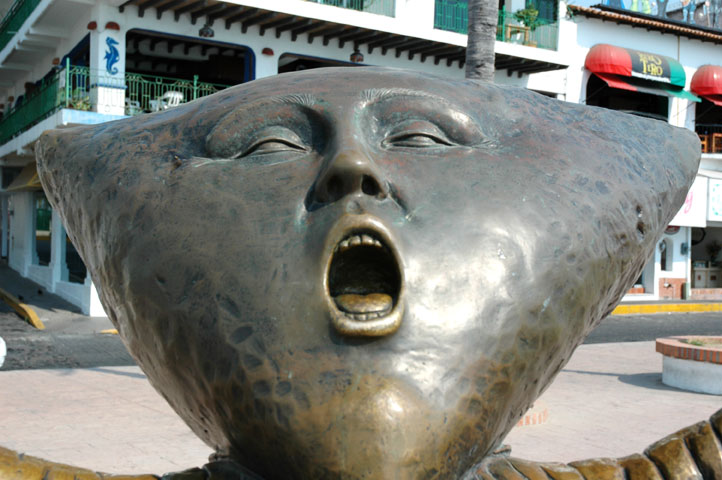 a close up of a metal head on a pedestal