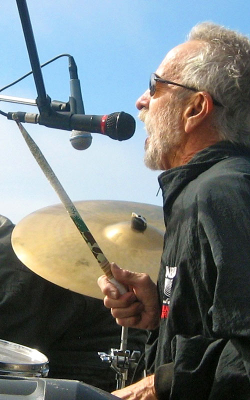 a man with glasses on playing drum on stage