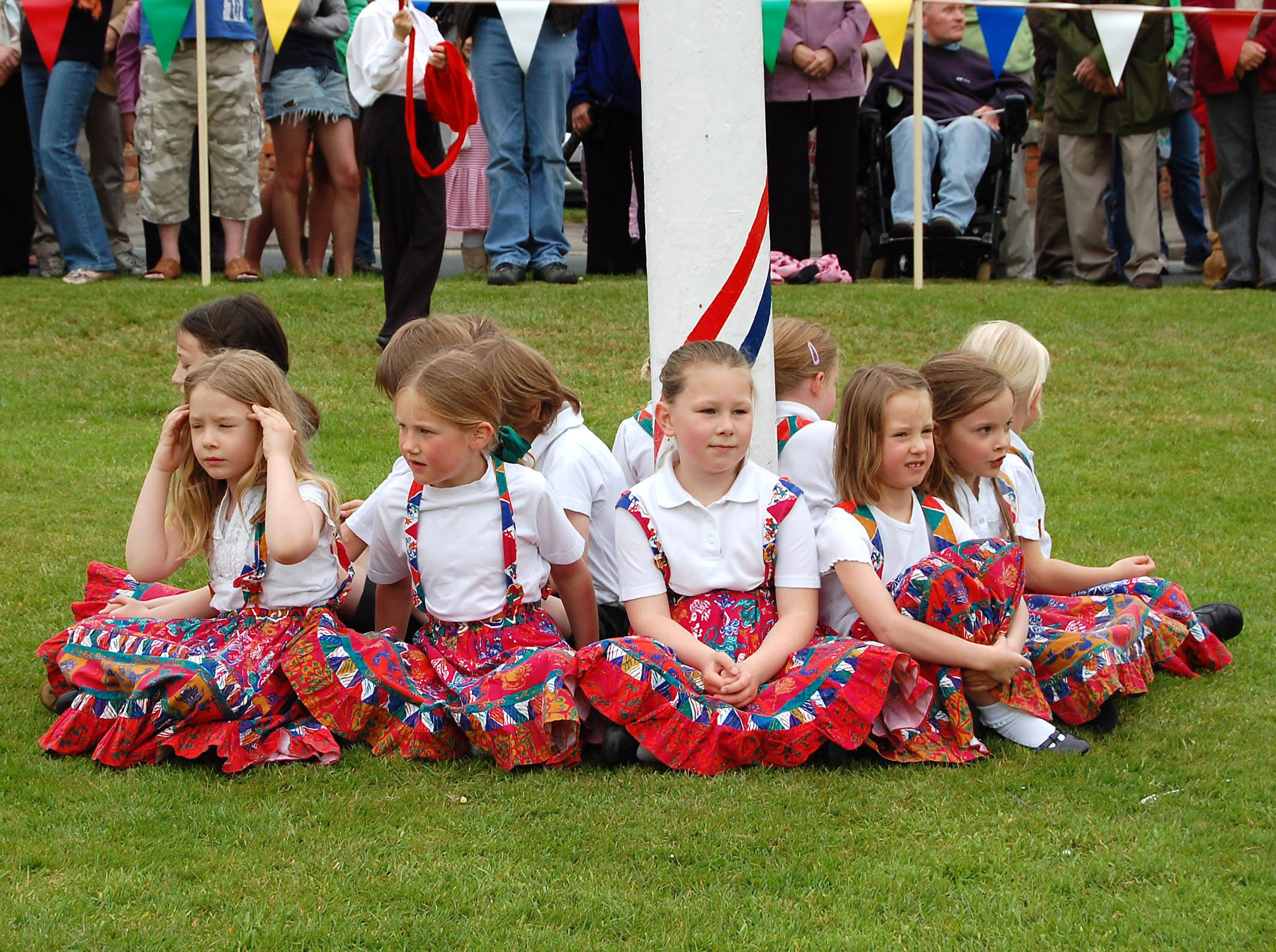 children sitting on the grass wearing a group of skirts