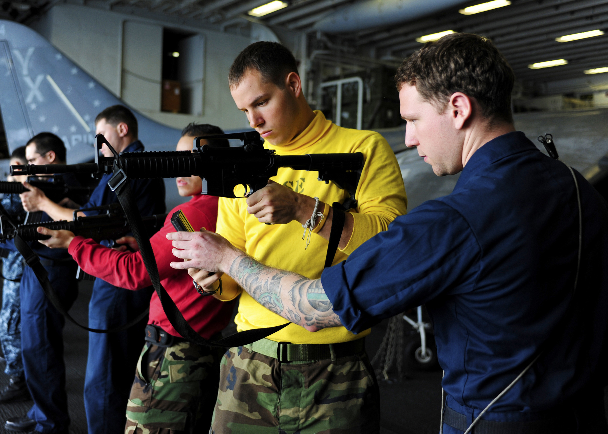 two men in uniforms are holding a machine gun