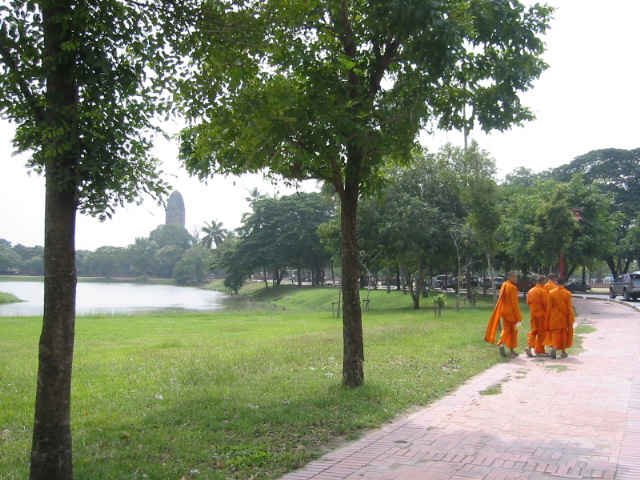 people dressed in orange robes walking down a walkway