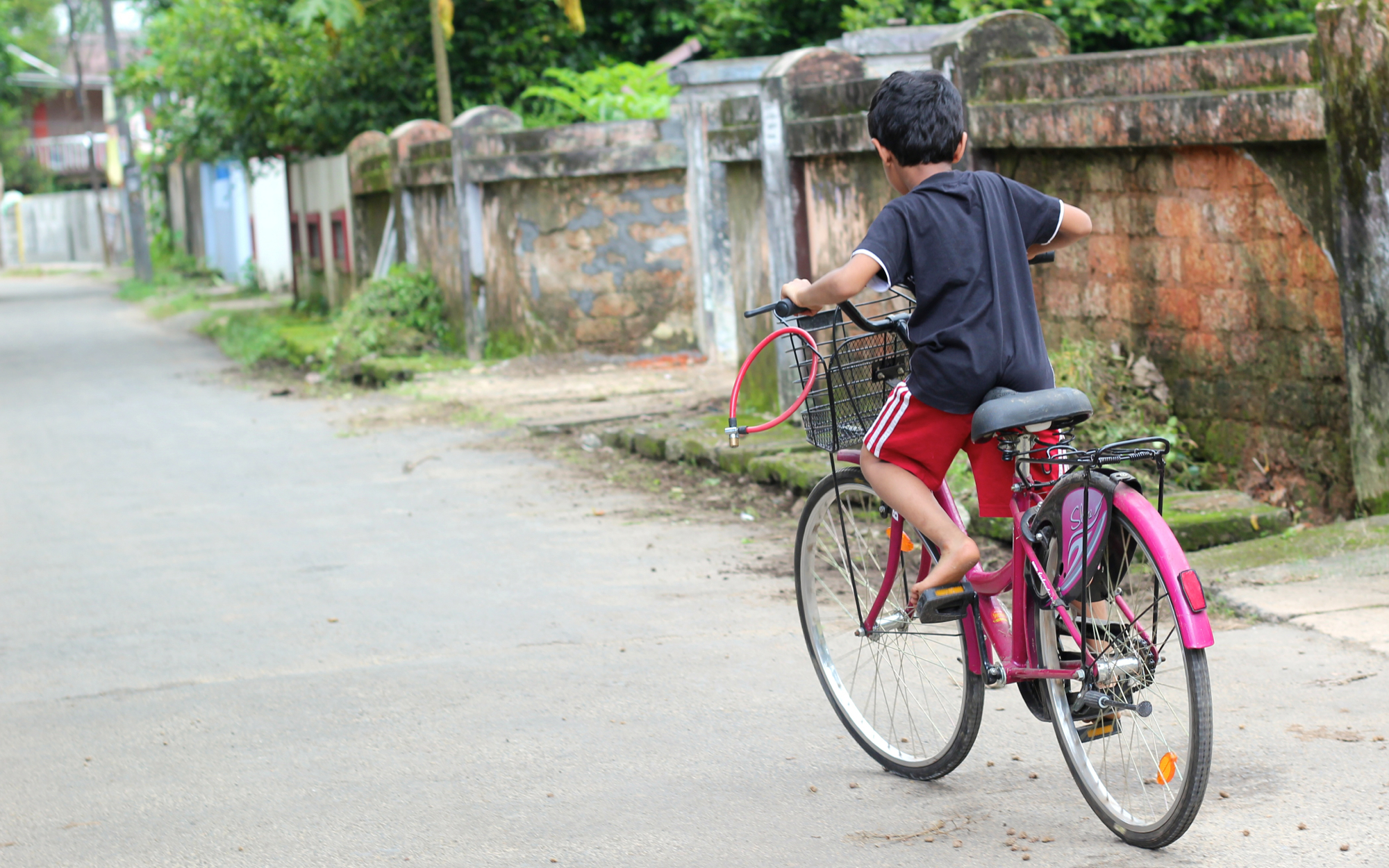 a boy riding a bike down a narrow road