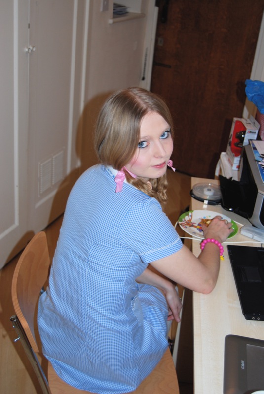 a woman sits at a desk using a computer