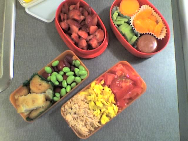 plastic containers filled with assorted food sitting on a table