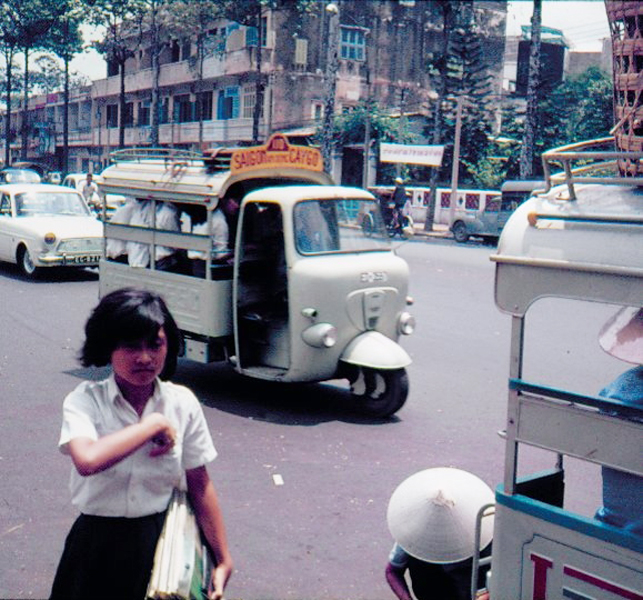 young woman in white shirt holding bag near old time vehicle