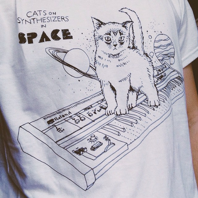 a  in a white t shirt has a cat on the keyboard