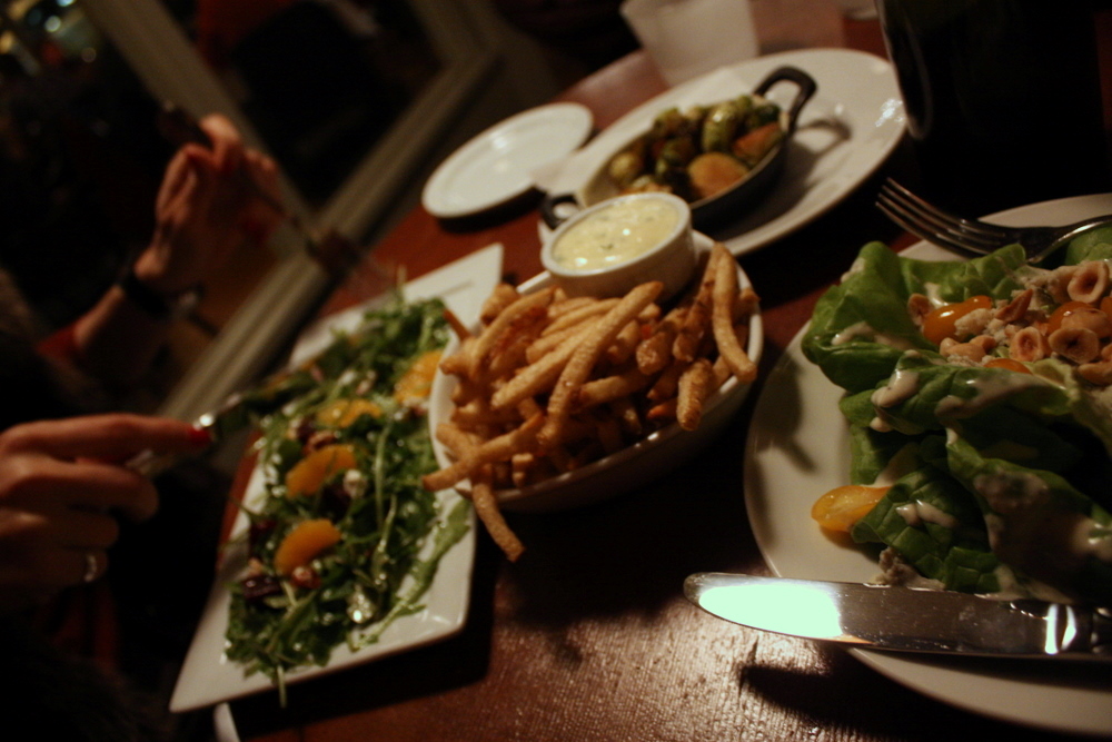 some plates of food including salad and fries