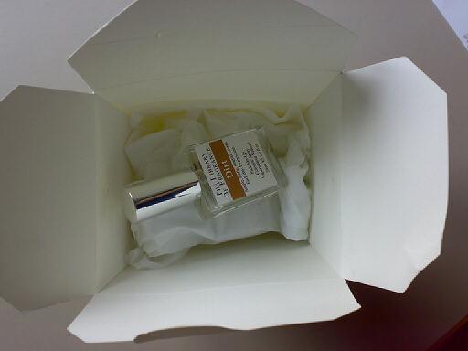 a bottle and some toiletries inside a white box