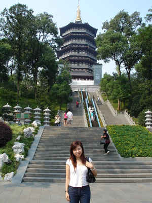a woman is standing in front of stairs leading up to a pagoda
