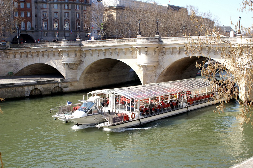 the river cruise boat is cruising under an old stone bridge