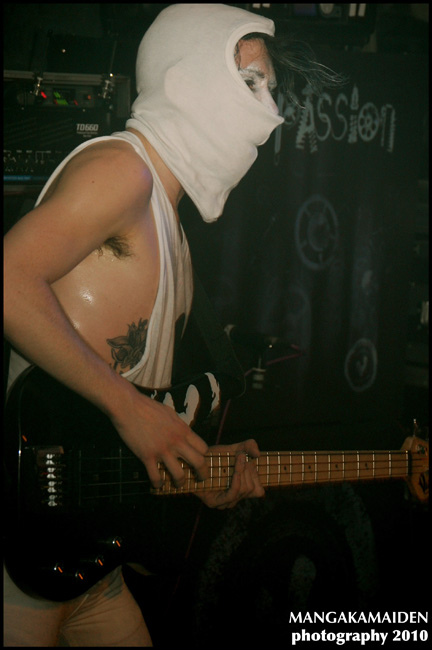 a man in white shirt with mask playing a guitar