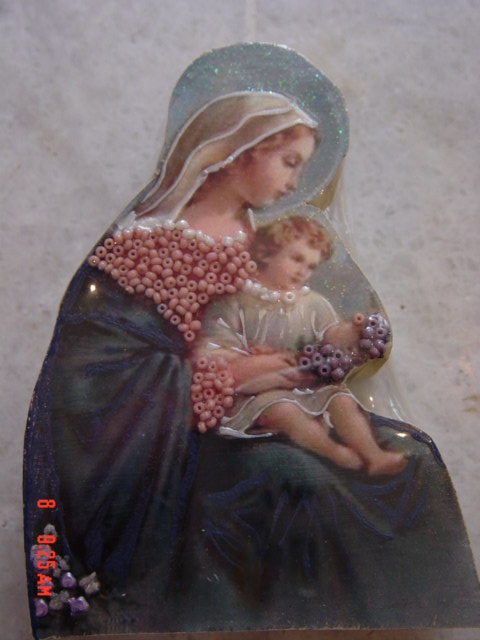 a glass figurine is holding a baby jesus