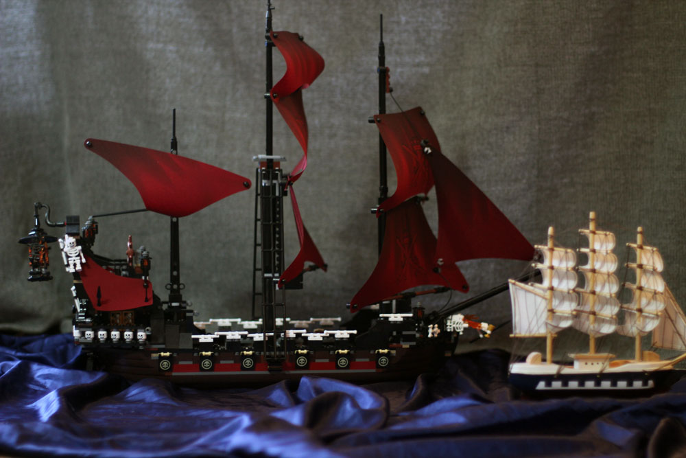 a lego pirate boat with red sails is pictured