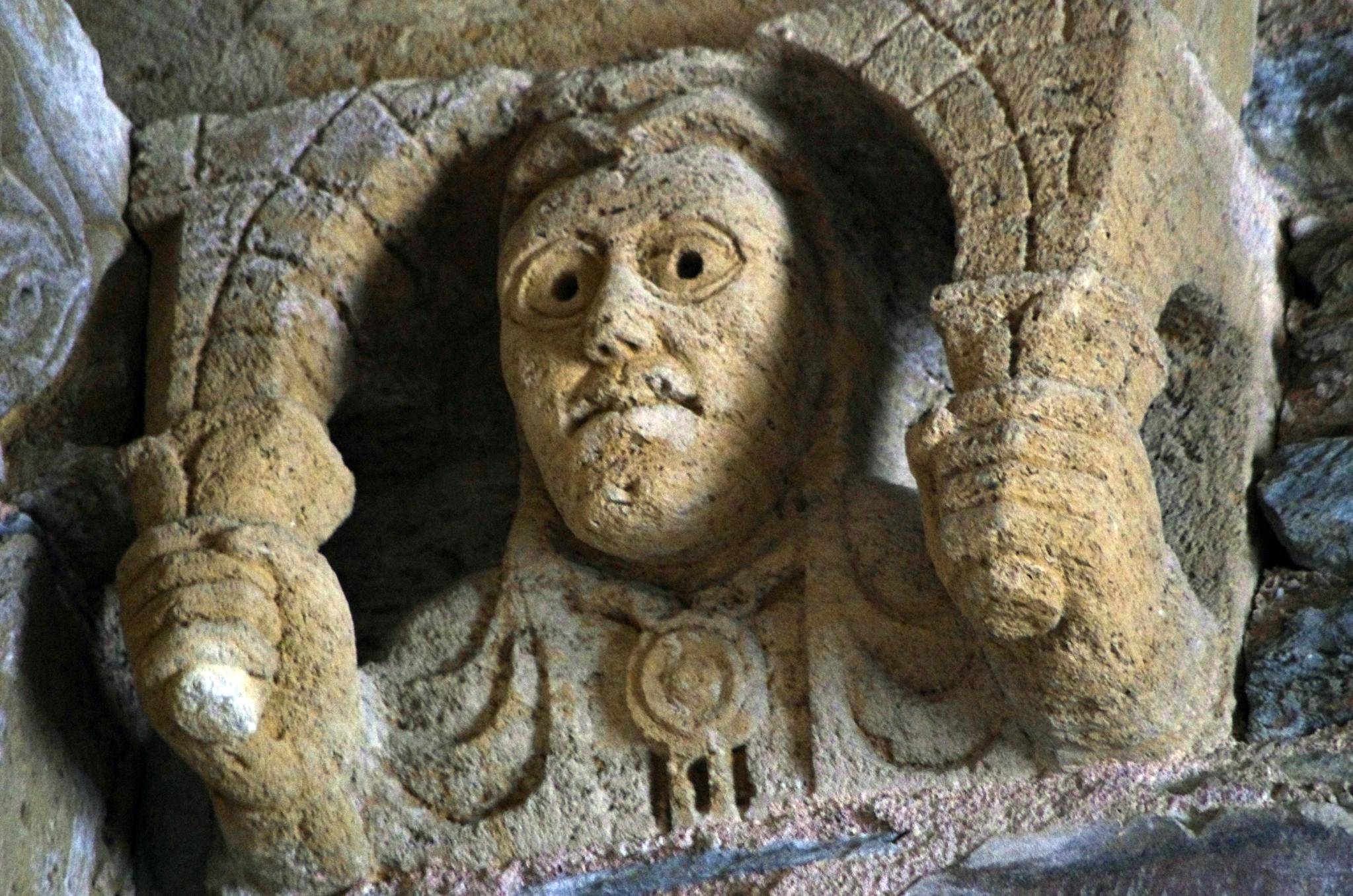 stone face carving is shown in a cave