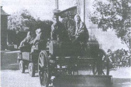 black and white image of men on a horse drawn carriage