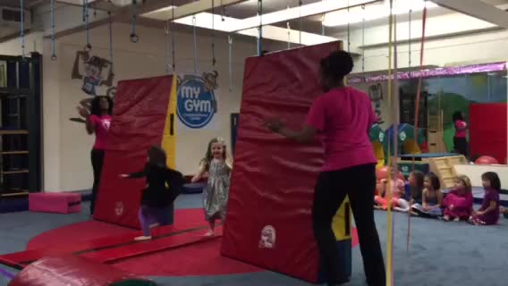 a girl and two little girls are on a gym course