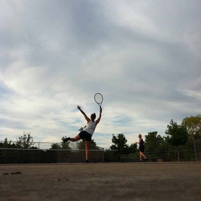 a tennis player holds a racket in the air