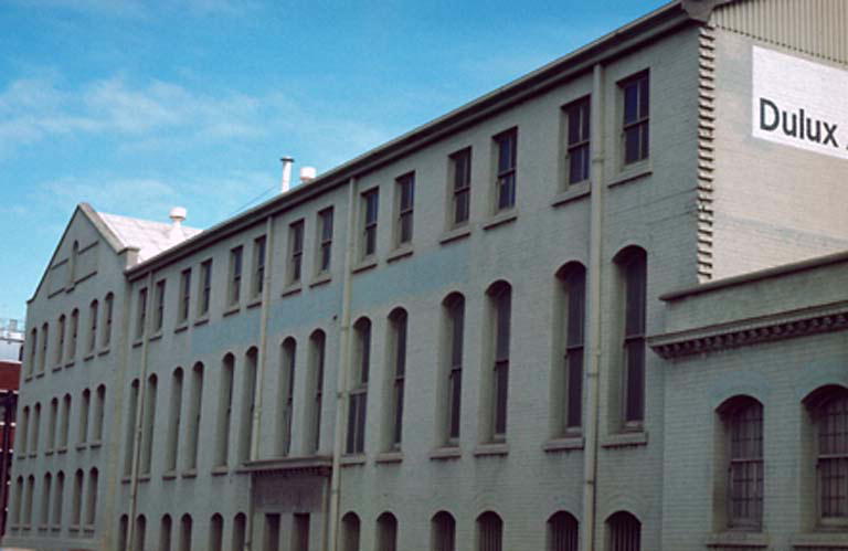 a large, grey building with windows and a large, square sign above it