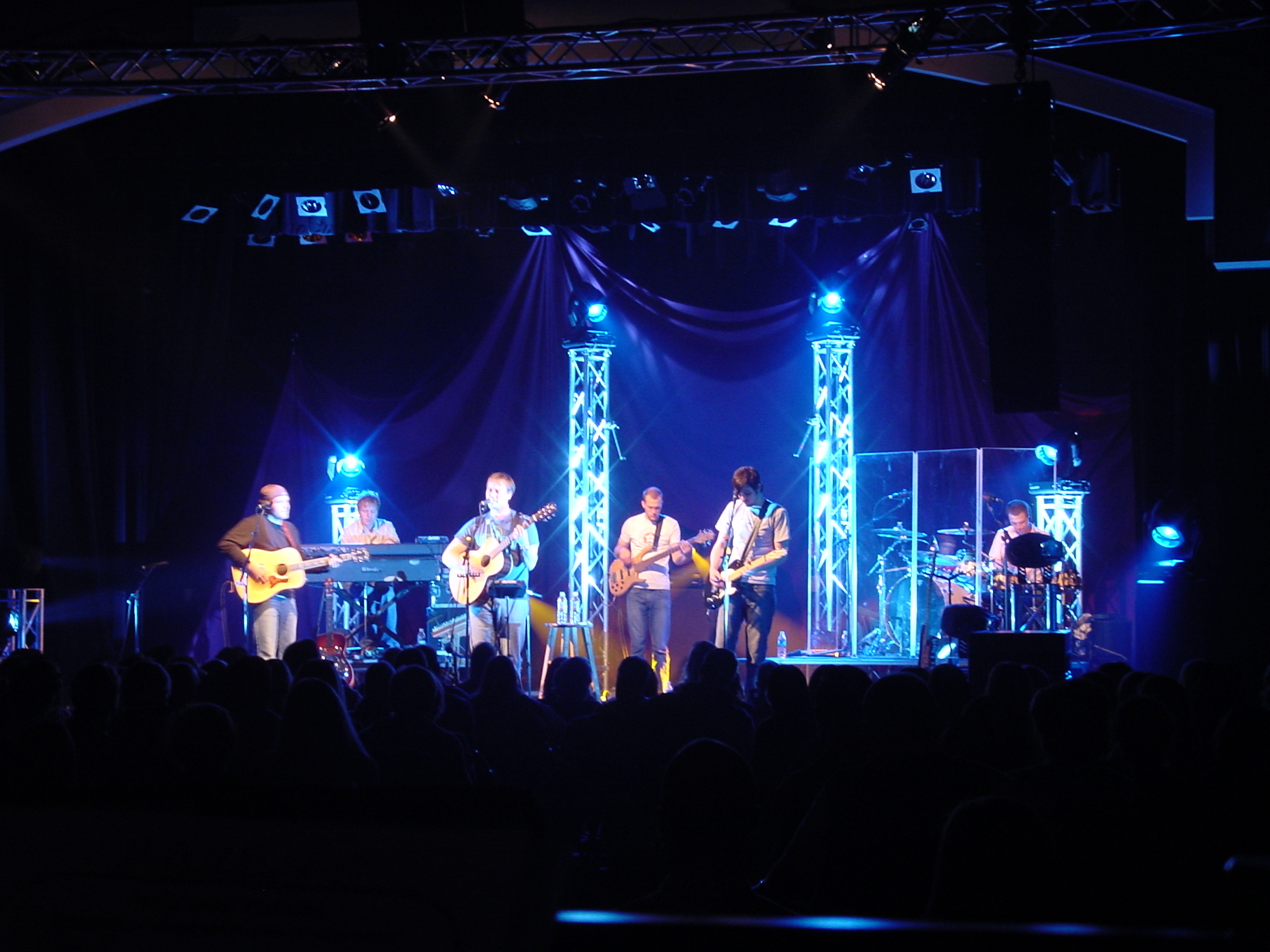 people on stage playing musical instruments at the same time