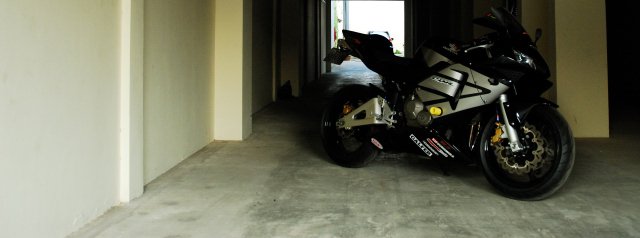 the motorcycle is parked near the large doorway