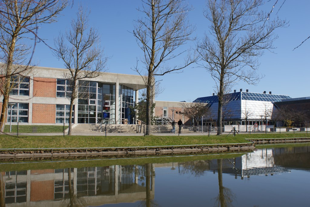 a water view of a building and tree's in the distance