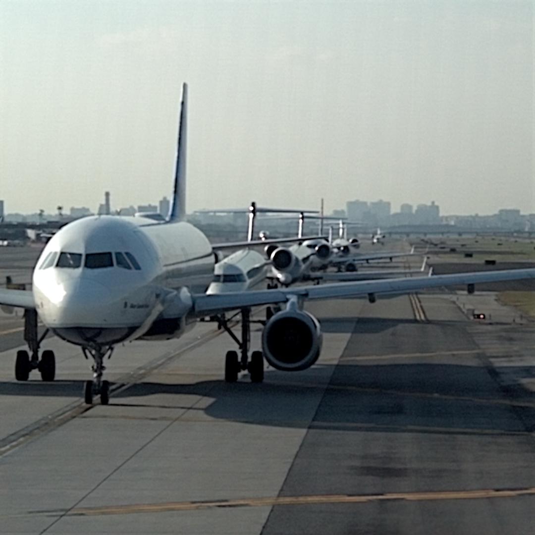 three planes are parked on the runway at an airport