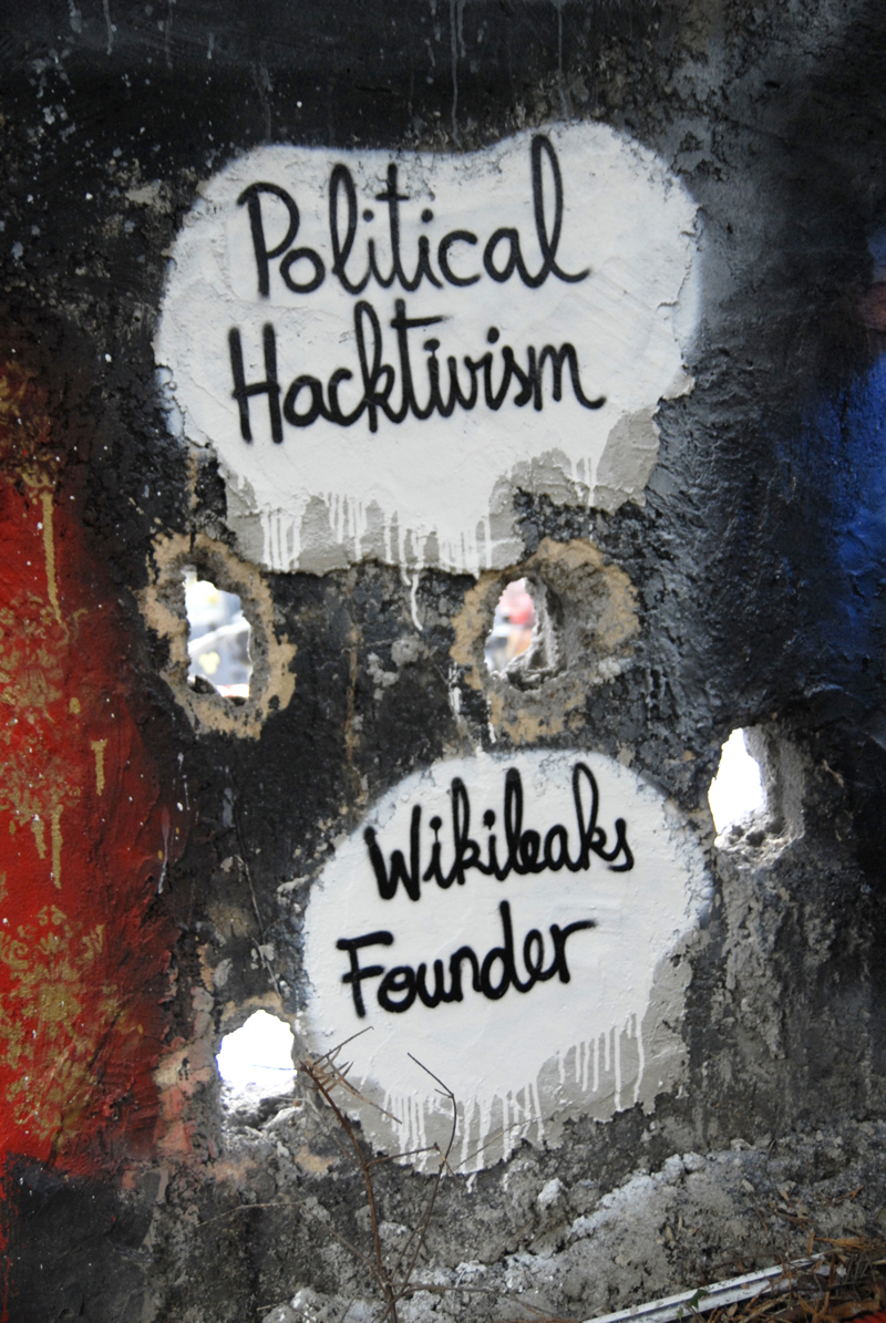 some stickers on the side of a pole with writing that reads political hacklin