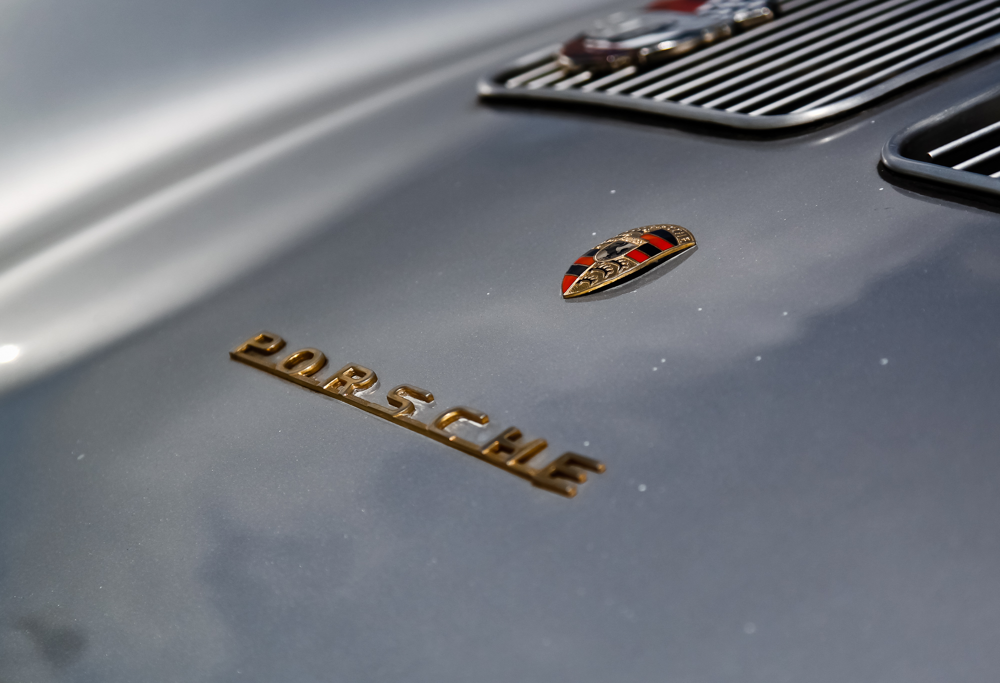 the emblem of a vintage car sits on the bonnet