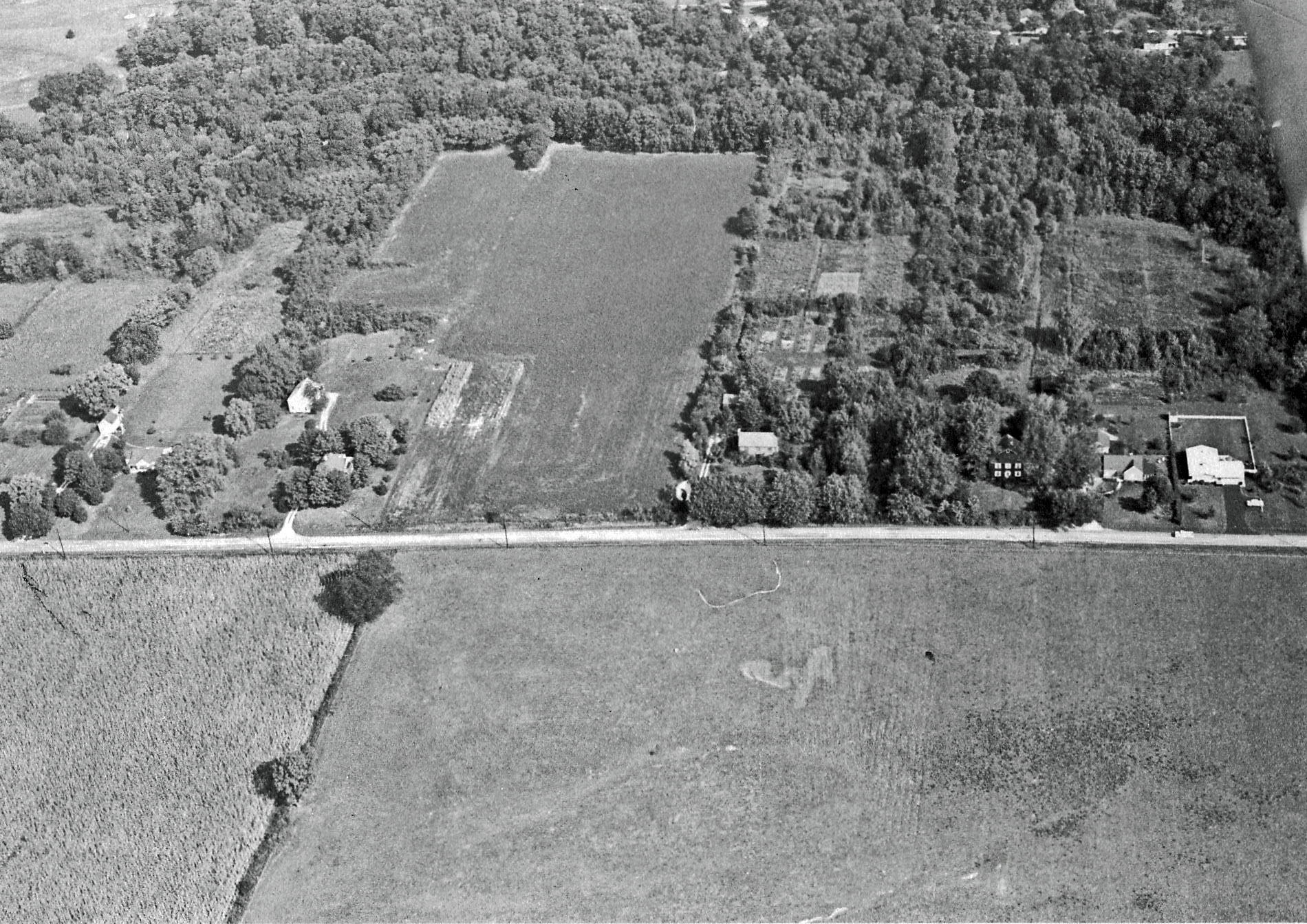 an aerial po showing the site of a rural area and a large field