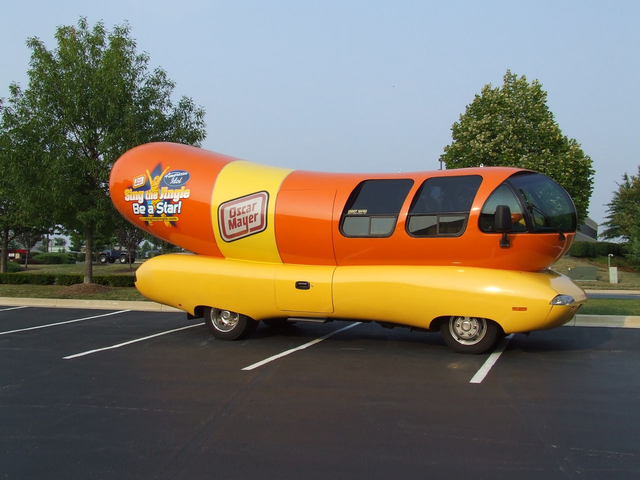 the giant mcdonald's  dog car is parked in a parking lot