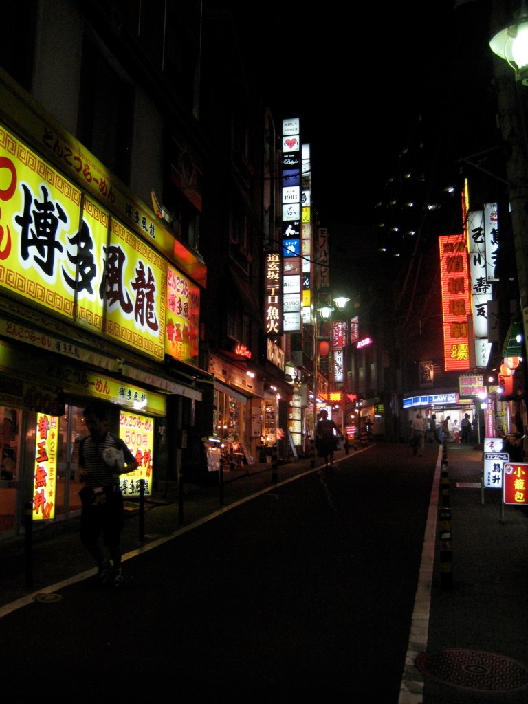 asian writing on lighted buildings in an urban city