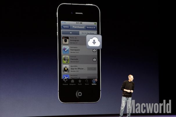 steve jobs standing on stage in front of an apple device