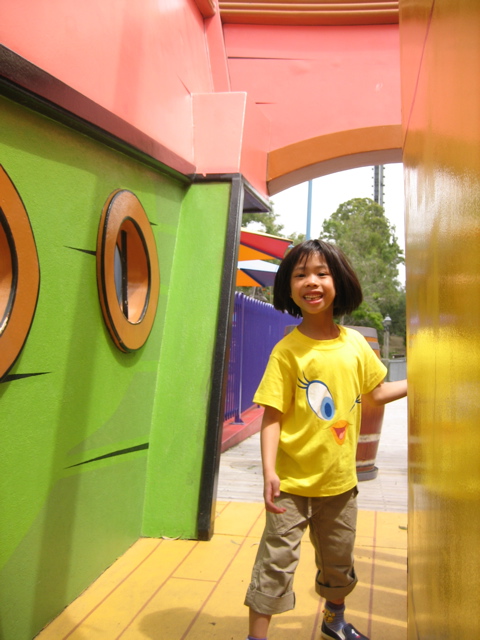 small child standing in doorway with colorful building behind him