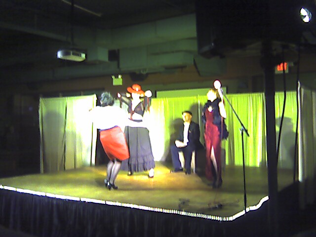 people in costume stand on a stage and perform on a set