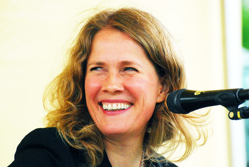 the woman smiles while she holds her hair blow dryer