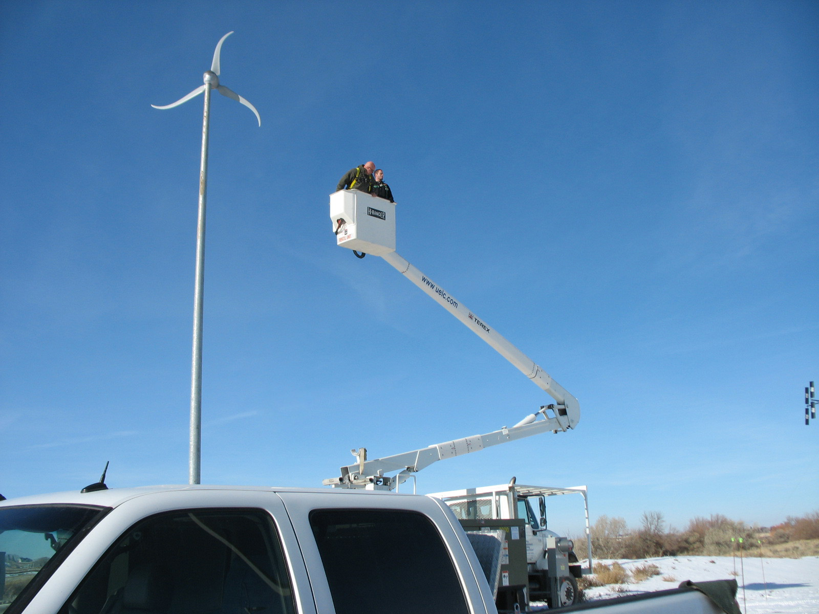 a crane is on top of a silver truck