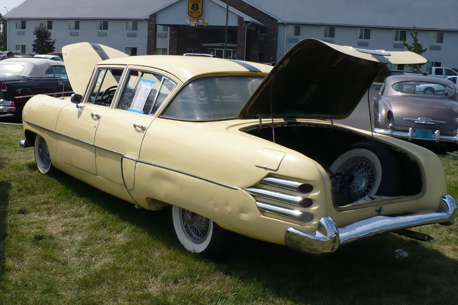 a vintage car with its trunk open on display