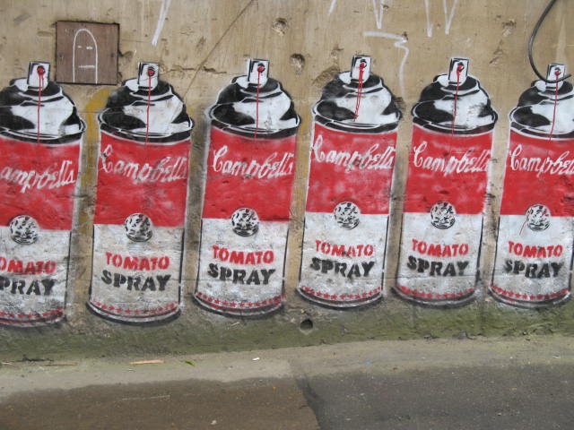 a group of can painted on the side of a building