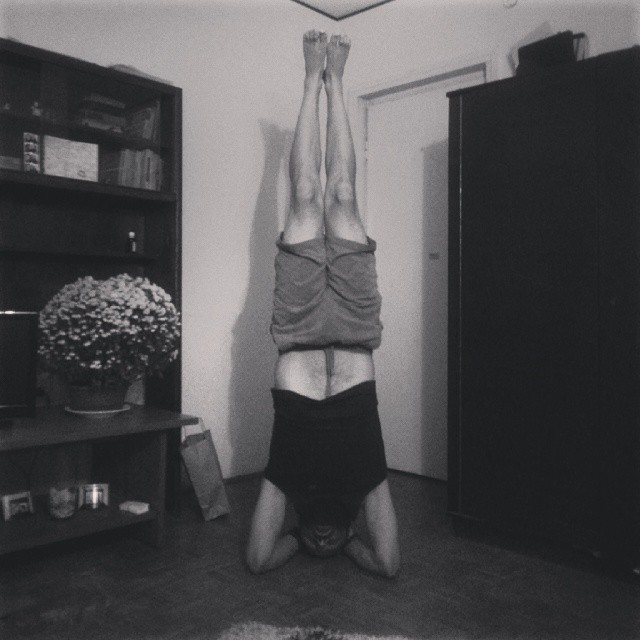 man doing handstands in the kitchen in front of the refrigerator