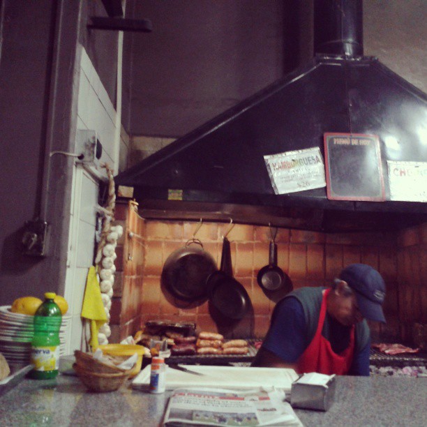 a man in blue is working under the oven