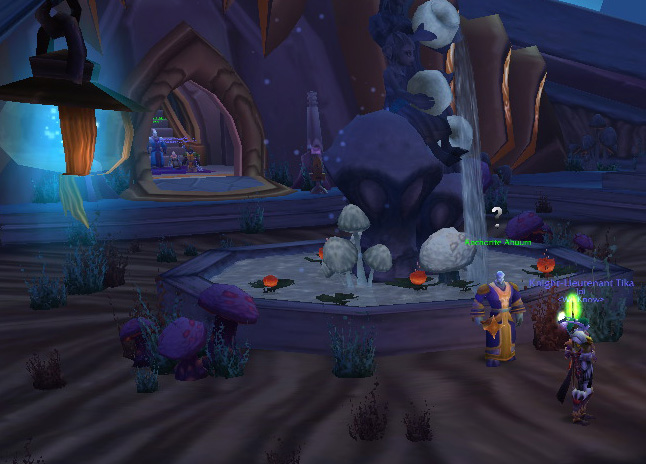 a game showing a dark purple scene and a woman with white hair standing in front of a fountain