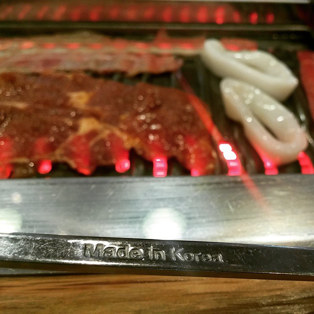 a close up of a grill with meat and garlic