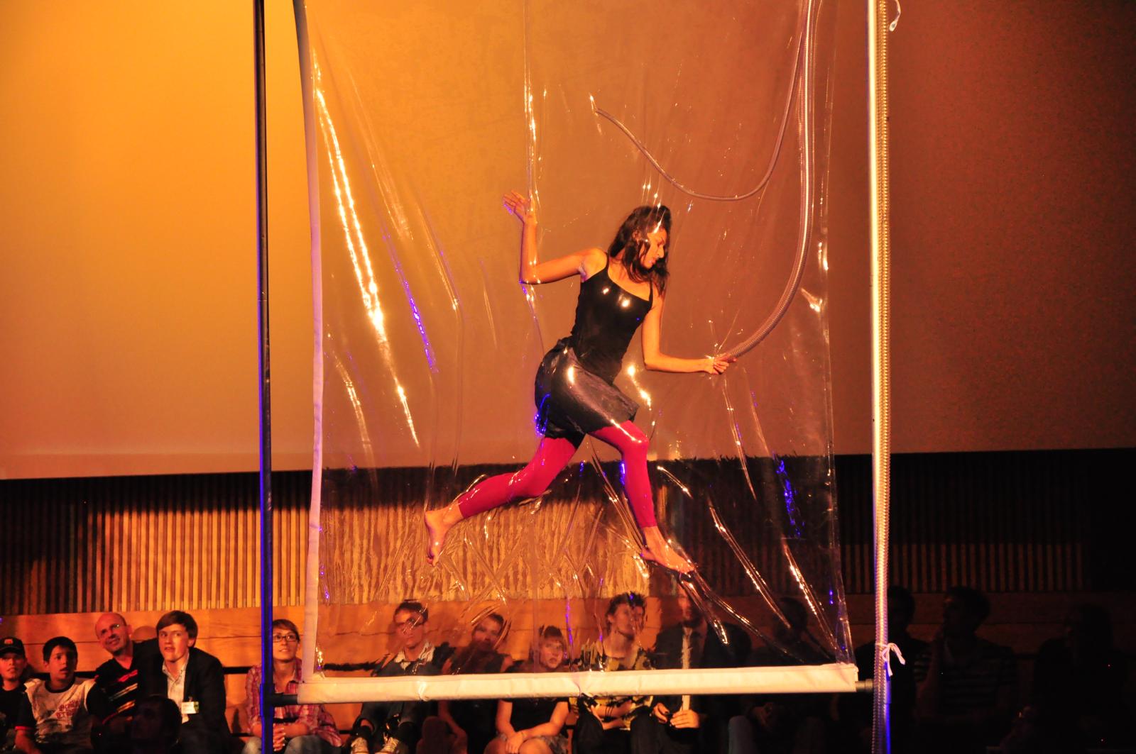 a woman is in the air on a pole