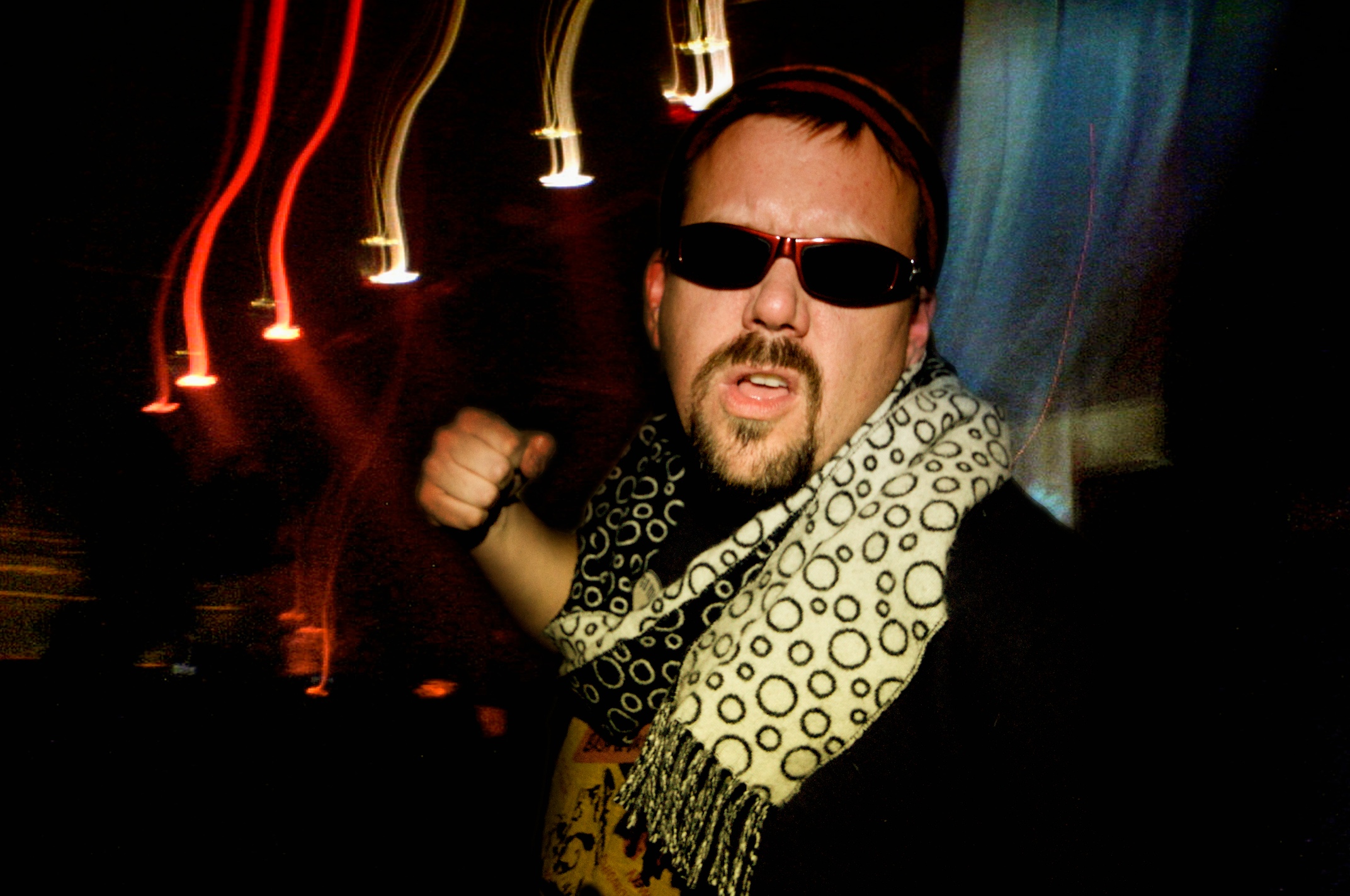a man with sunglasses and a scarf around his neck