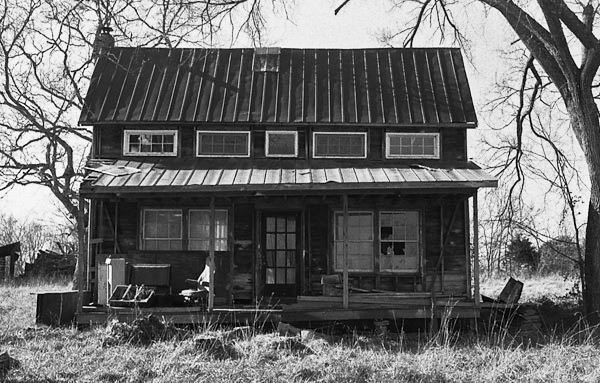 an old shack with windows that are all black and white