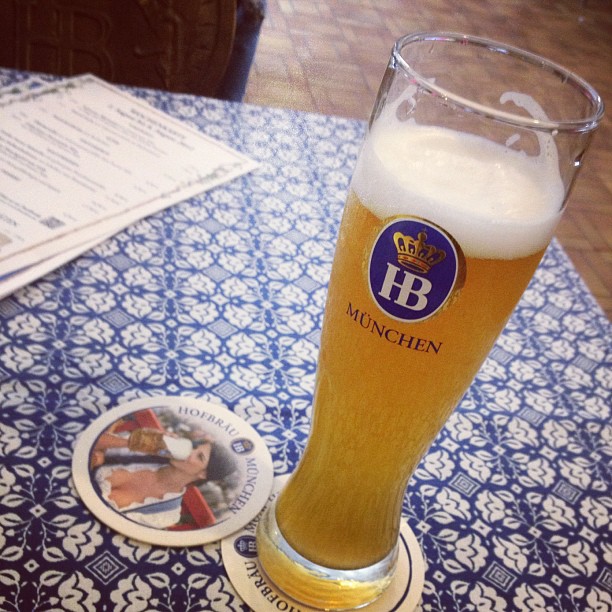 a beer glass sitting on top of a blue and white table cloth