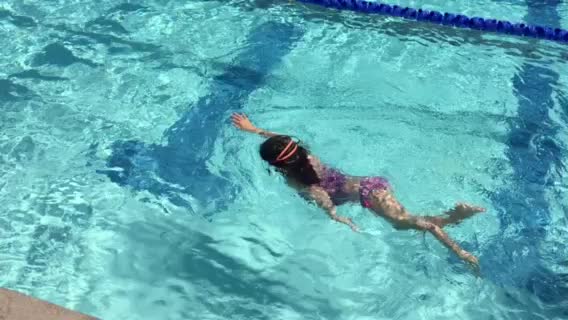 girl in swimsuit floating in a swimming pool