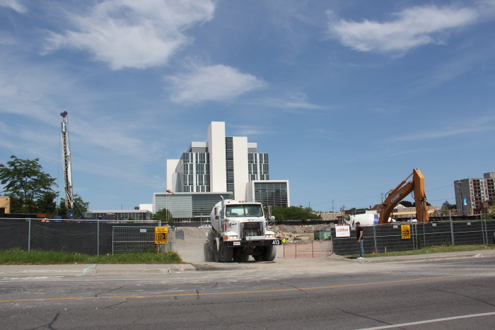 a construction vehicle parked behind a fence and buildings