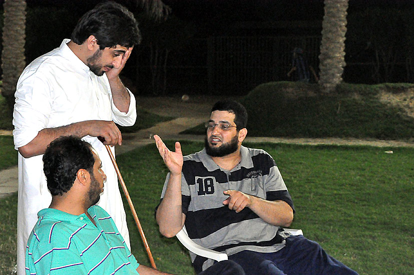 the men are talking while sitting on the lawn