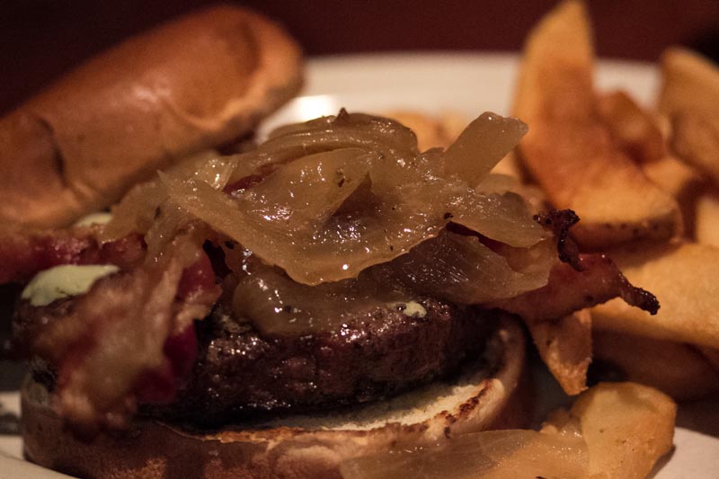 the beef is sitting next to a pile of fries on the plate